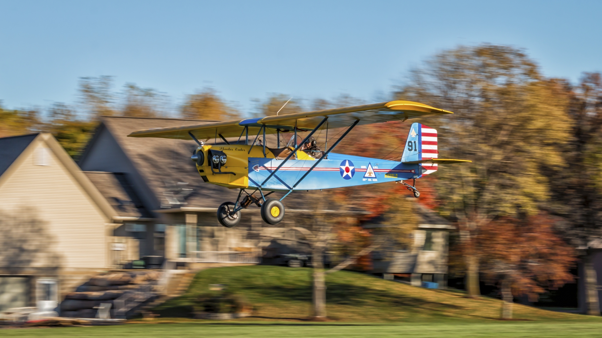 Pietenpol Aircamper experimental homebuilt aircraft taking off with motion blur, house visible in the background